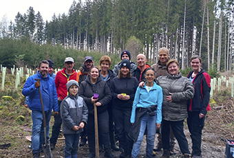Gruppenfoto von Mitarbeitern in einem Waldstück